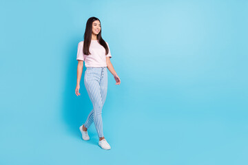 Fototapeta na wymiar Full length body size view of attractive cheerful thin content girl walking isolated over bright blue color background
