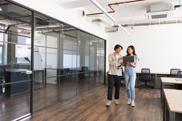 Young couple renting work space for start up business having informal meeting in open plan office