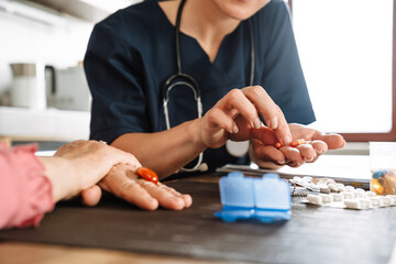 A close-up shot of pills prescribed by a doctor to an elderly woman