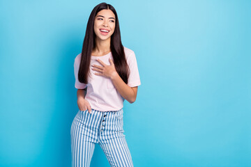 Photo of young girl happy positive smile hand on chest laugh appreciate look empty space isolated over blue color background