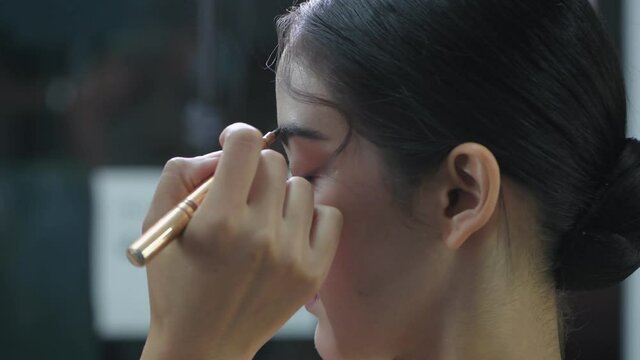 Beauty concept of 4k Resolution. A makeup artist is painting the eyebrows of a model in a beauty salon.