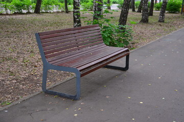 wooden bench in the city park along the path