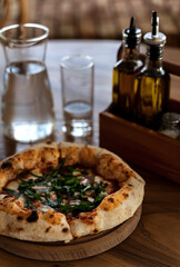 Pizza on wooden table in vintage style. Italian restaurant background for your design.