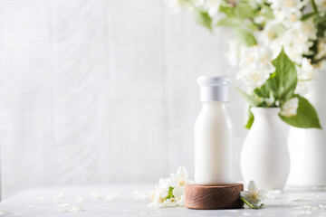 Obraz na płótnie Canvas Cosmetic detergent with jasmine extract. Mockup of cream, shampoo, soap. Copy space.