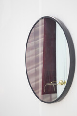 Black framed mirror on a white wall