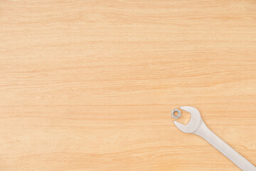 Minimal style of tools or hardware equipment as wrench or spanner tighten nut be corner of wooden background and texture with copy space. Minimal hardware tools concept