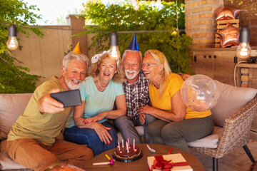 Senior friends taking a selfie at a birthday party