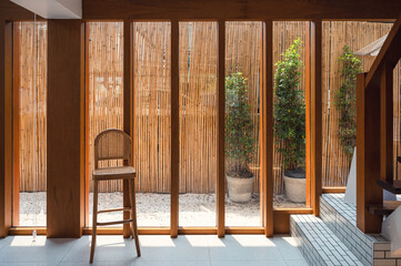 Interior of wooden glass window with weave chair and sunlight in retro house