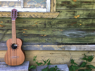 guitar on aged wooden wall of country house, copy spaced