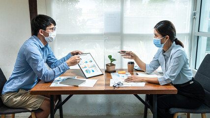 Asian business man showing financial chart to colleagues and discussion about new project