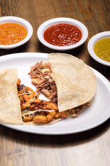 Pastor meat tacos with corn tortillas. Gringa with cheese. Mexican food on wooden background. Mexican taco concept. Mexican food concept