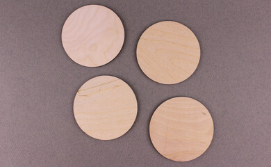 Round wooden coasters on a gray background. Wooden blank discs