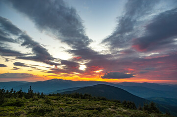 Beautiful multicolored sunset in the Carpathian mountains in summer. Evening landscape