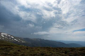 Obraz premium Spring mountains in the snow on the background of a green forest