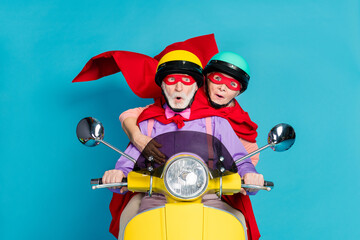 Photo of shocked grey haired retired pensioner couple wife husband ride bike wear cape mask...