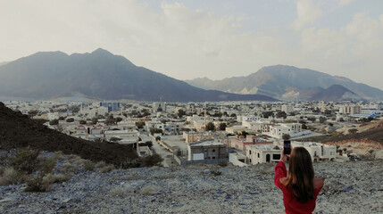Female traveller make a panoramic photo of the old city