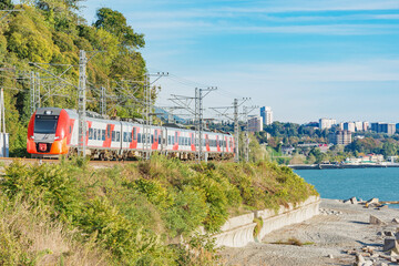 Obraz premium Passenger train moves along Black sea coast. Sochi.