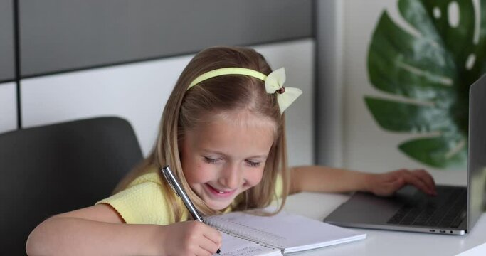 Caucasian little girl school pupil studying online from home, watching web class lesson or listening tutor by video call elearning during coronavirus covid-19 pandemic self isolation. Slow motion