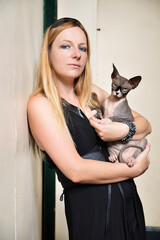 Beautiful blonde woman with a sphynx cat