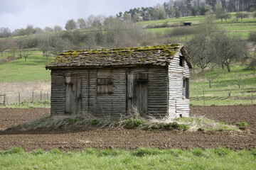 Alte Hütte aus Holz steht im Acker