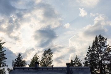 Windy evening cloud spotting. Clouds are passing by. Sun is shining behind the clouds