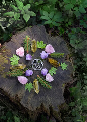 mineral gemstones, pentagram amulet and forest leaves on natural background. Magic quartz stones...