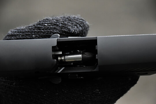 Closeup view of 9mm automatic pistol chamber which is holding in hand, selective and soft focus.