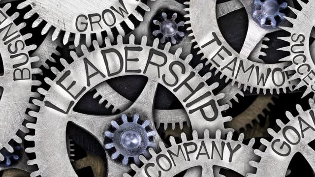 Group of rotating tooth wheels with Leadership sign imprinted on metal surface. Concept of Teamwork, Success and Competence. High quality 4k video.