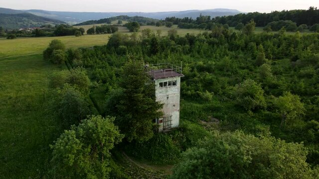 Aerial of the inner german border between GDR and FRG with watchtower, remnants of the cold war and the Berlin wall in 4k, drone