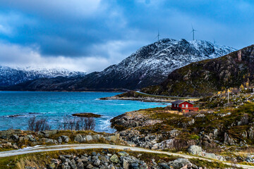 Rote Hütte am Ufer des Fjord an einem stürmischen Tag in Troms, in der Nähe von Tromsö,...