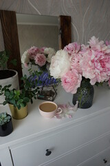 Bouquet of pink peonies on the dresser in the bedroom