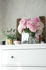 Bouquet of pink peonies on the dresser in the bedroom