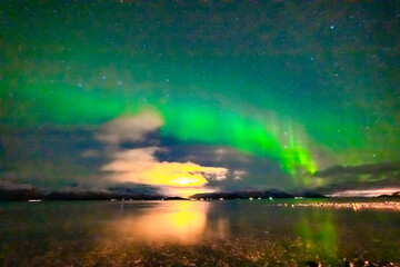 Nordlichter über dem Fjord in Troms bei Tromsö. Aurora Borealis in the sky, heavenly light in the...