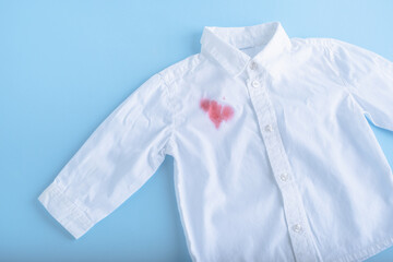 Juice spilled on a white shirt. isolated on blue background
