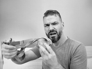 Unhappy shocked man with chronic breathing issues surprised by using  CPAP machine sitting on the...