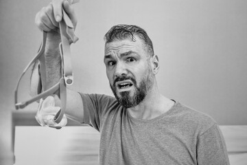 Unhappy shocked man with chronic breathing issues surprised by using  CPAP machine sitting on the bed in bedroom. Healthcare, CPAP, Obstructive sleep apnea therapy, snoring concept
