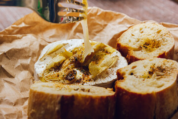 DIY baked cheese camembert instruction step by step. step 5 Camembert tasting. melted cheese stretches. cheese with white mold.moldy cheese