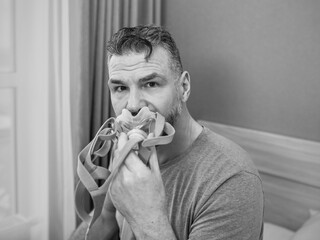 Unhappy shocked man with chronic breathing issues surprised by using  CPAP machine sitting on the...