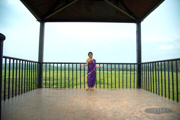 Beautiful Indian young girl in Traditional Saree posing outdoors