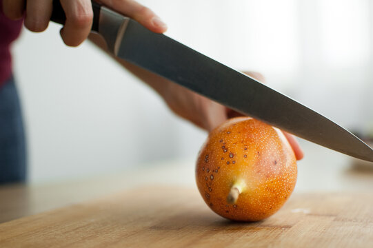 Fresh organic ripe granadilla or yellow passion fruit cut in half on a wooden board. Exotic fruits, healthy eating concept
