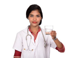 Healthy eating or lifestyle concept: Smiling female doctor holding a glass of clear fresh water