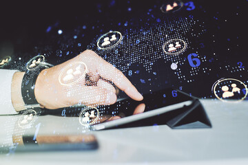 Double exposure of social network icons concept with world map and hand working with a digital tablet on background. Networking concept