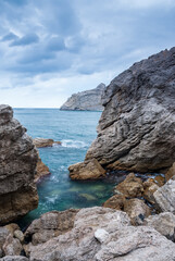 Fototapeta na wymiar Seascape of the Crimean coast. Waves break into beautiful splashes against rocks.