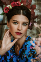 Naklejka premium Portrait of beautiful young woman with red lips and hairdo with flowers