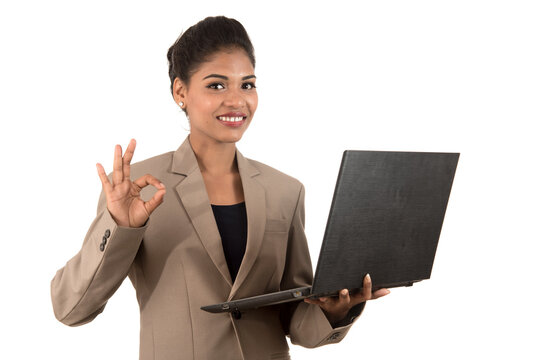 Happy excited business woman holding laptop and showing thumbs up isolated on a white background