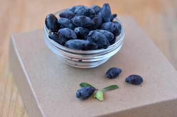 blue honeysuckle berry in a transparent cup on the table
