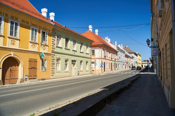 Petrovaradin is historic town on right bank of Danube in Serbian province of Vojvodina, now part of Novi Sad. Old town street with colorful building facades