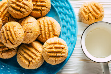 Peanut cookies in blue plate on white wooden background