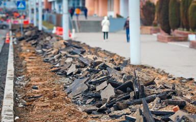 Road repair. Broken asphalt on pedestrian zone in the city street. Road repair work. Construction of pedestrian zone. Damaged asphalt surface