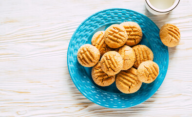 Peanut cookies in blue plate on white wooden background